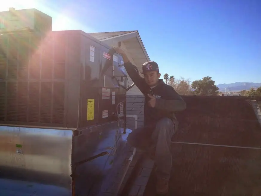 HVAC technician performing AC Tune-Up on a rooftop unit in Danbury